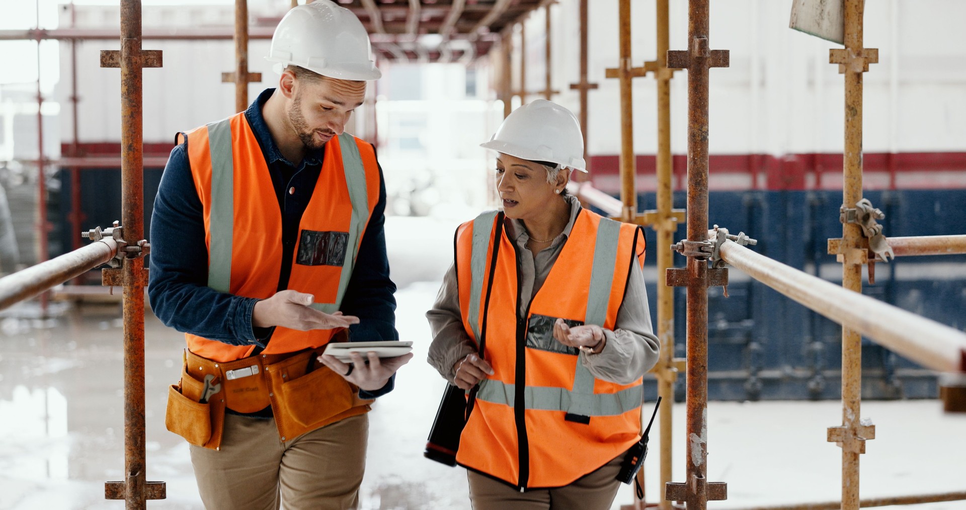 Construction site, teamwork and people on tablet for project management, planning or industrial collaboration.  Engineering team on digital tech of blueprint or floor plan solution or problem solving
